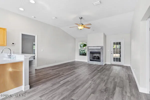 a view of a kitchen with a sink a fireplace and wooden floor