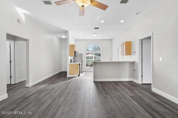 a view of kitchen with wooden floor and electronic appliances