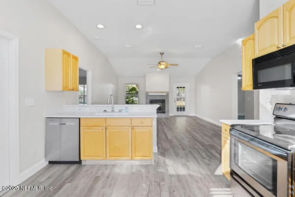 a kitchen with stainless steel appliances granite countertop a sink a stove a microwave a counter space and cabinets