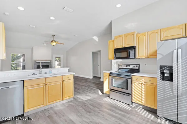 a kitchen with a sink a counter top space stainless steel appliances and cabinets