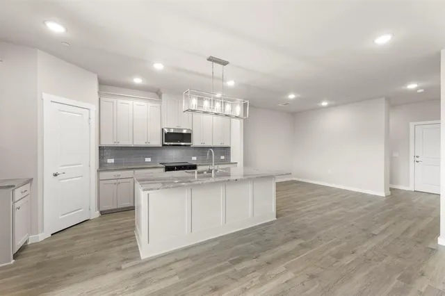 a kitchen with kitchen island a sink stainless steel appliances and cabinets