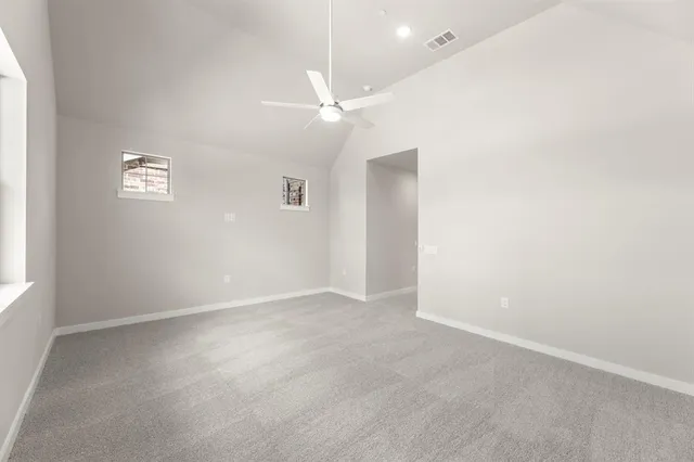 an empty room with a ceiling fan and a window