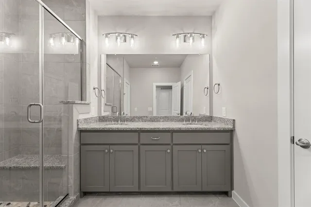 a bathroom with a granite countertop sink a mirror and a shower