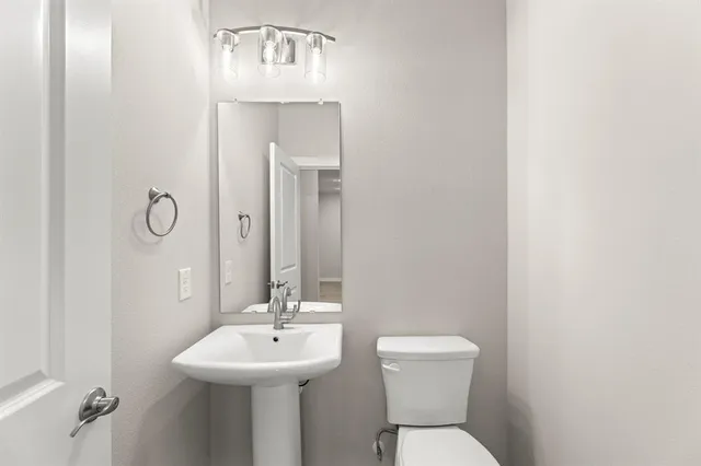 a bathroom with a sink mirror and toilet