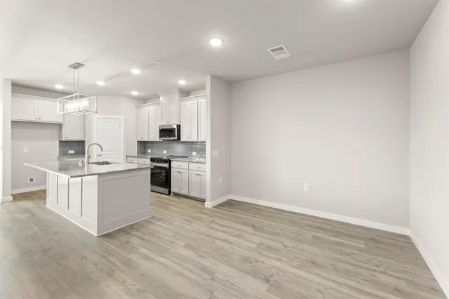 a kitchen with white cabinets and stainless steel appliances