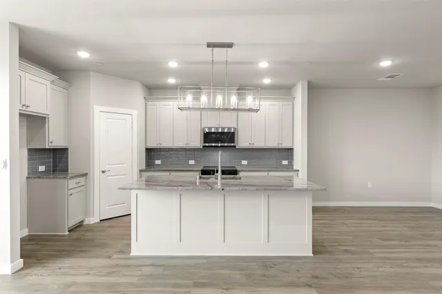 a kitchen with kitchen island a sink stainless steel appliances and cabinets