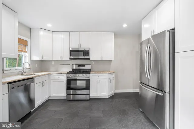 a kitchen with stainless steel appliances granite countertop a refrigerator sink and stove