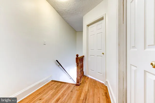 a view of a hallway with wooden floor and staircase