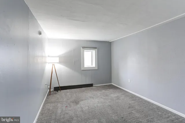 an empty room with a fireplace and a window