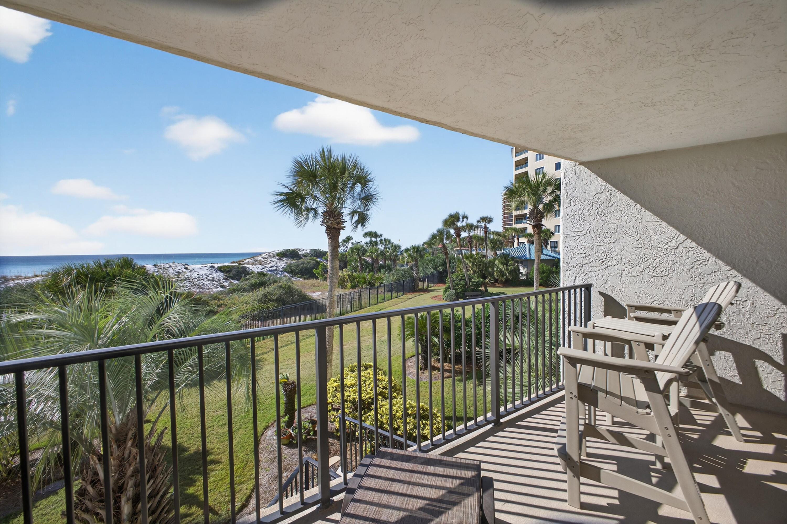 4024 Beachside 1, Unit 4024 Miramar Beach, FL 32550 - Photo 26 of 56 a view of a balcony with wooden chairs and floor to ceiling window