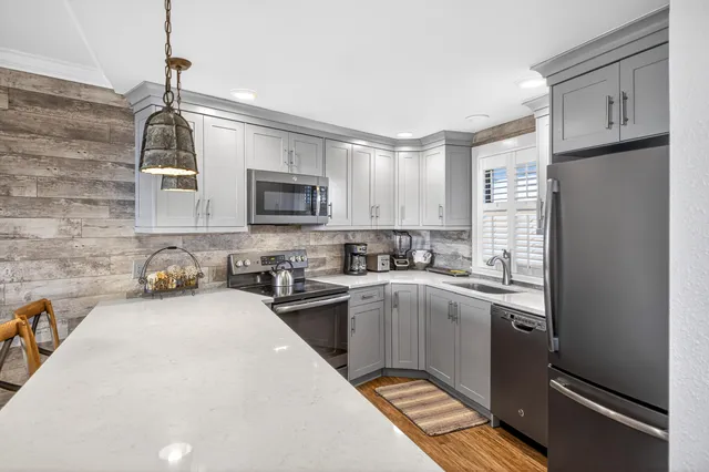 a kitchen with stainless steel appliances granite countertop a sink stove and microwave