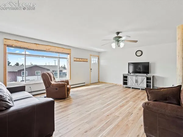 a living room with furniture a flat screen tv and a floor to ceiling window