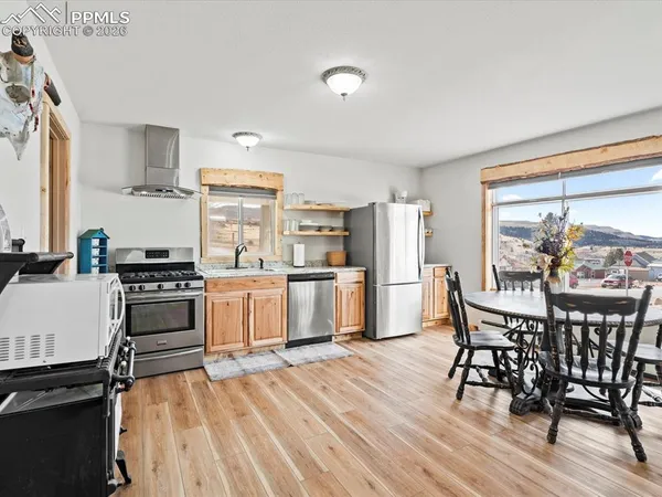 a kitchen with granite countertop a table chairs stove and cabinets