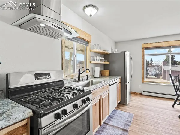 a kitchen with stainless steel appliances granite countertop a stove and a refrigerator