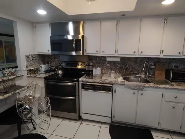a kitchen with a sink stainless steel appliances and cabinets