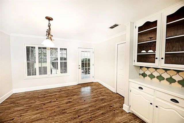a view of an empty room with window and cabinet