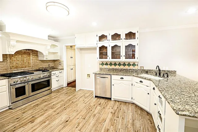 a kitchen with granite countertop a stove oven and sink