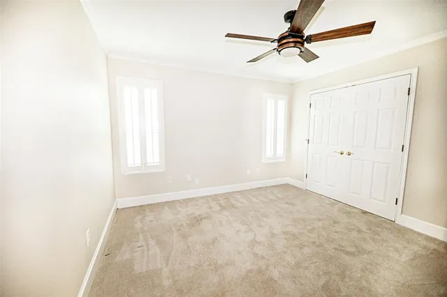 an empty room with windows and fan