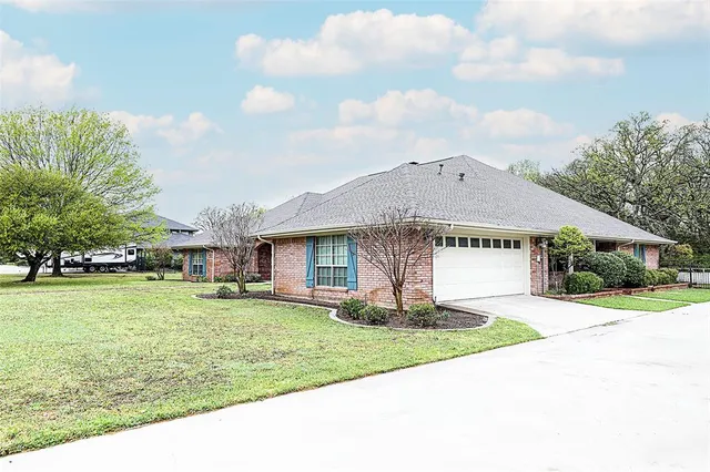 a front view of a house with a yard and trees