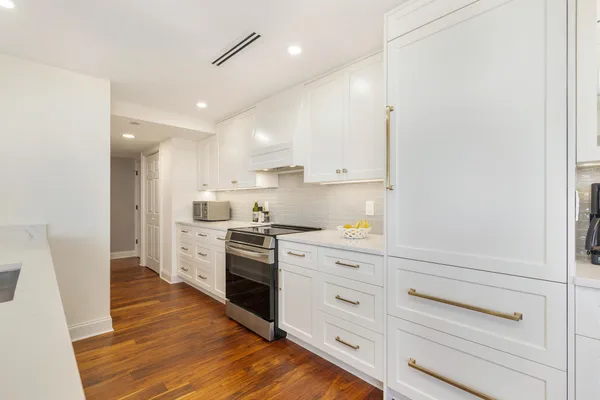a kitchen with granite countertop white cabinets and white appliances