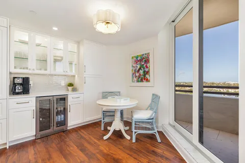 a view of a dining room with furniture a rug and wooden floor
