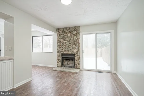 an empty room with windows and fireplace