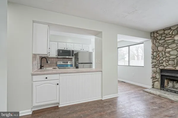a kitchen with granite countertop white cabinets and window