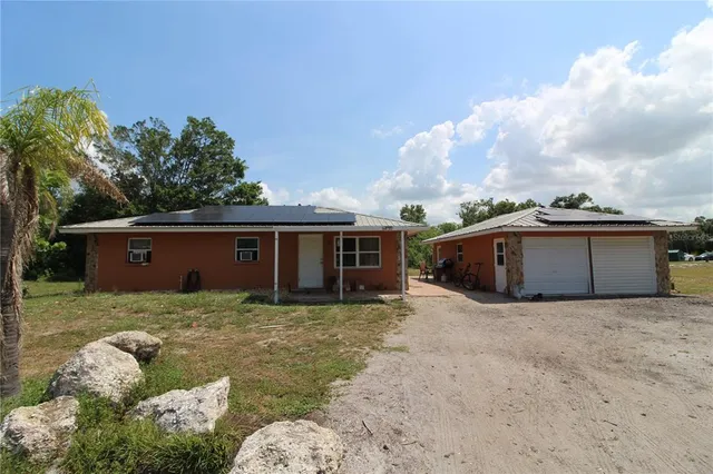 a view of a house with a big yard and a large tree