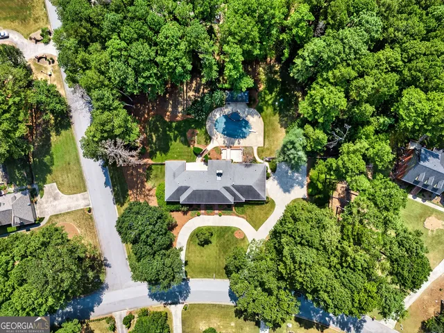 an aerial view of a house with swimming pool and garden