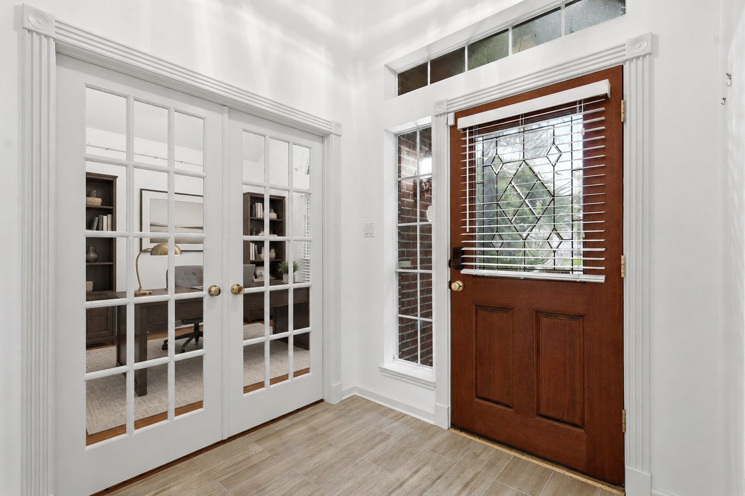 5815 Pheasant Ridge Lane Houston, TX 77041 - Photo 3 of 43 Grand entry featuring soaring ceilings and a transom window above the elegant front door, filling the space with natural light. Notice the beautiful custom woodwork and trim details surrounding the doorways, adding timeless character and charm. French glass doors open to a private home office, perfect for working from home or a quiet retreat. Virtually staged to showcase its potential, this home is vacant, move-in ready, and waiting for its new owner!