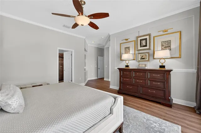 a bedroom with a bed a painting on the wall and a window