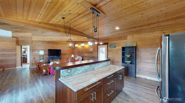 a kitchen with stainless steel appliances granite countertop a stove refrigerator and wooden floor