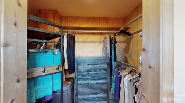 a view of walk in closet with clothes and shoes