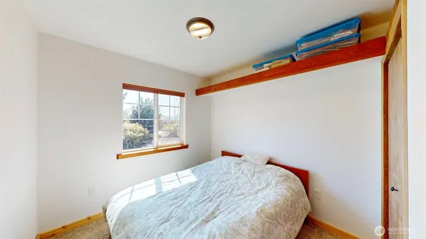 a bed sitting in a bedroom next to a window