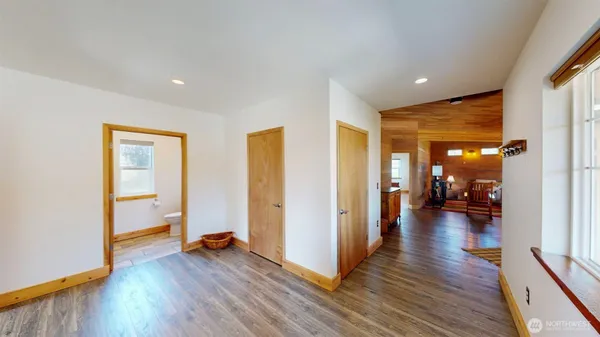 a view of a hallway with wooden floor and a living room