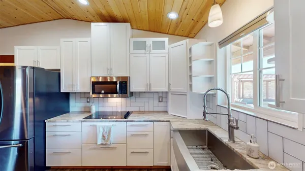 a kitchen with refrigerator a stove a sink and a window