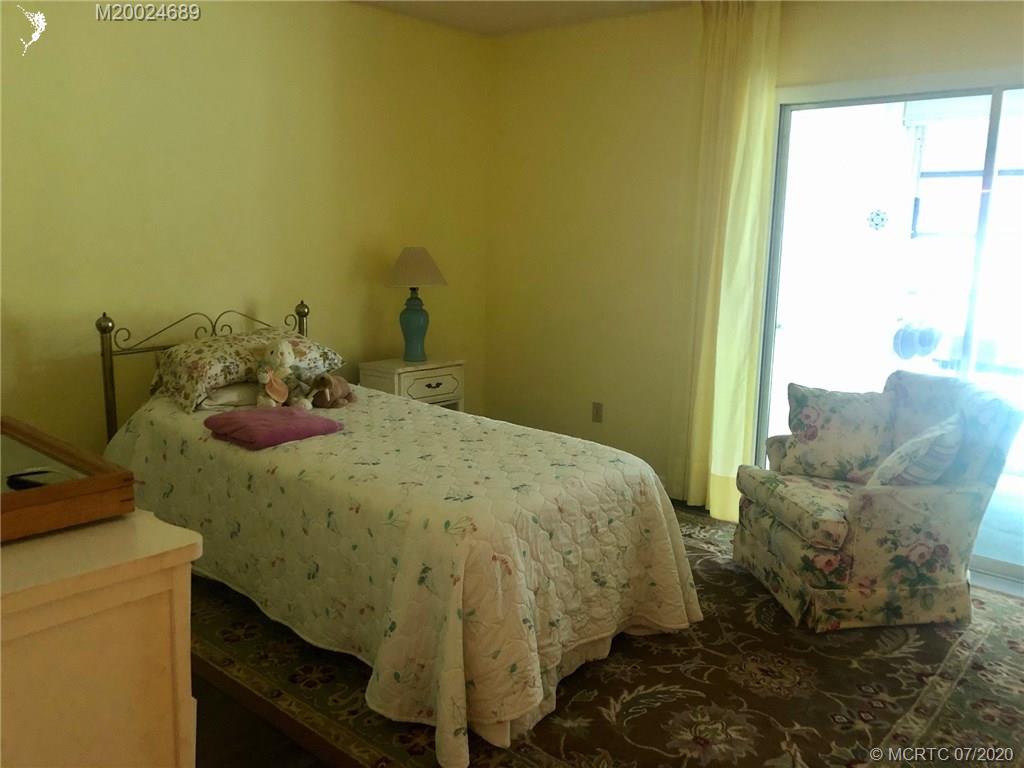 1225 Northwest 21st Street, Unit 2908 Stuart, FL 34994 - Photo 21 of 56 a bed sitting in a bedroom next to a window