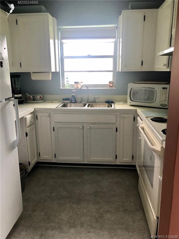 1225 Northwest 21st Street, Unit 2908 Stuart, FL 34994 - Photo 3 of 56 a kitchen with granite countertop white cabinets sink and white appliances