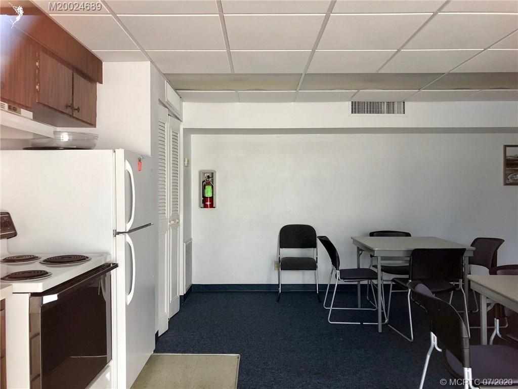 1225 Northwest 21st Street, Unit 2908 Stuart, FL 34994 - Photo 45 of 56 a kitchen with a refrigerator and table chairs
