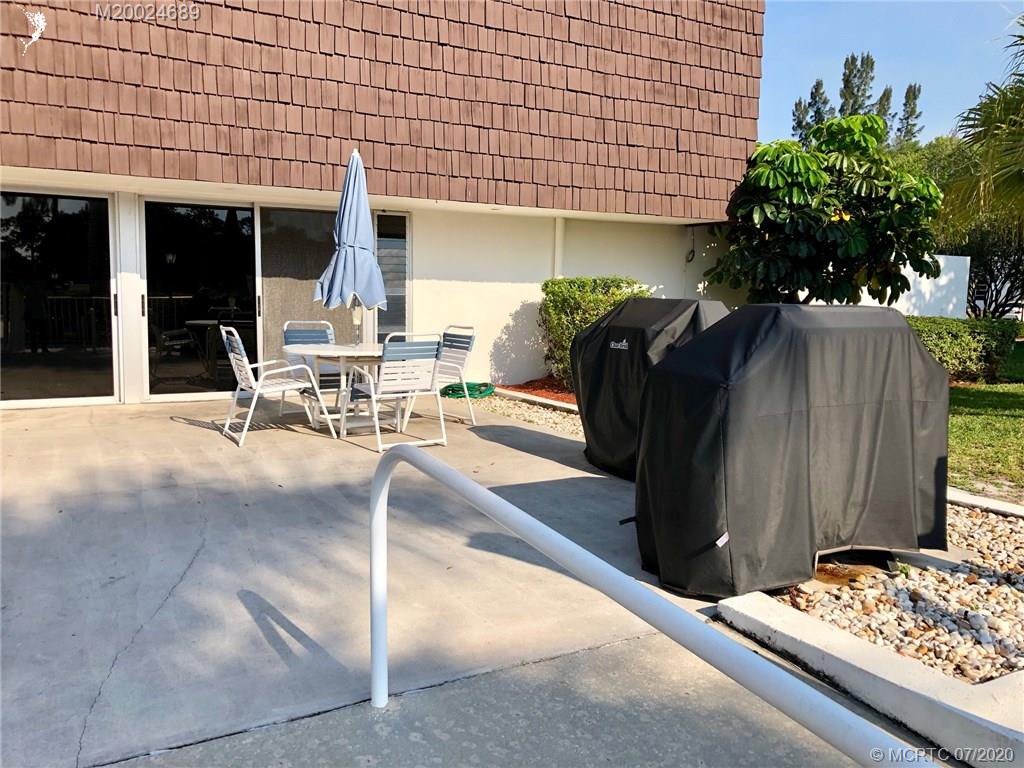 1225 Northwest 21st Street, Unit 2908 Stuart, FL 34994 - Photo 51 of 56 a view of a patio with table and chairs and potted plants