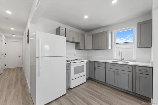 a kitchen with white cabinets and white appliances