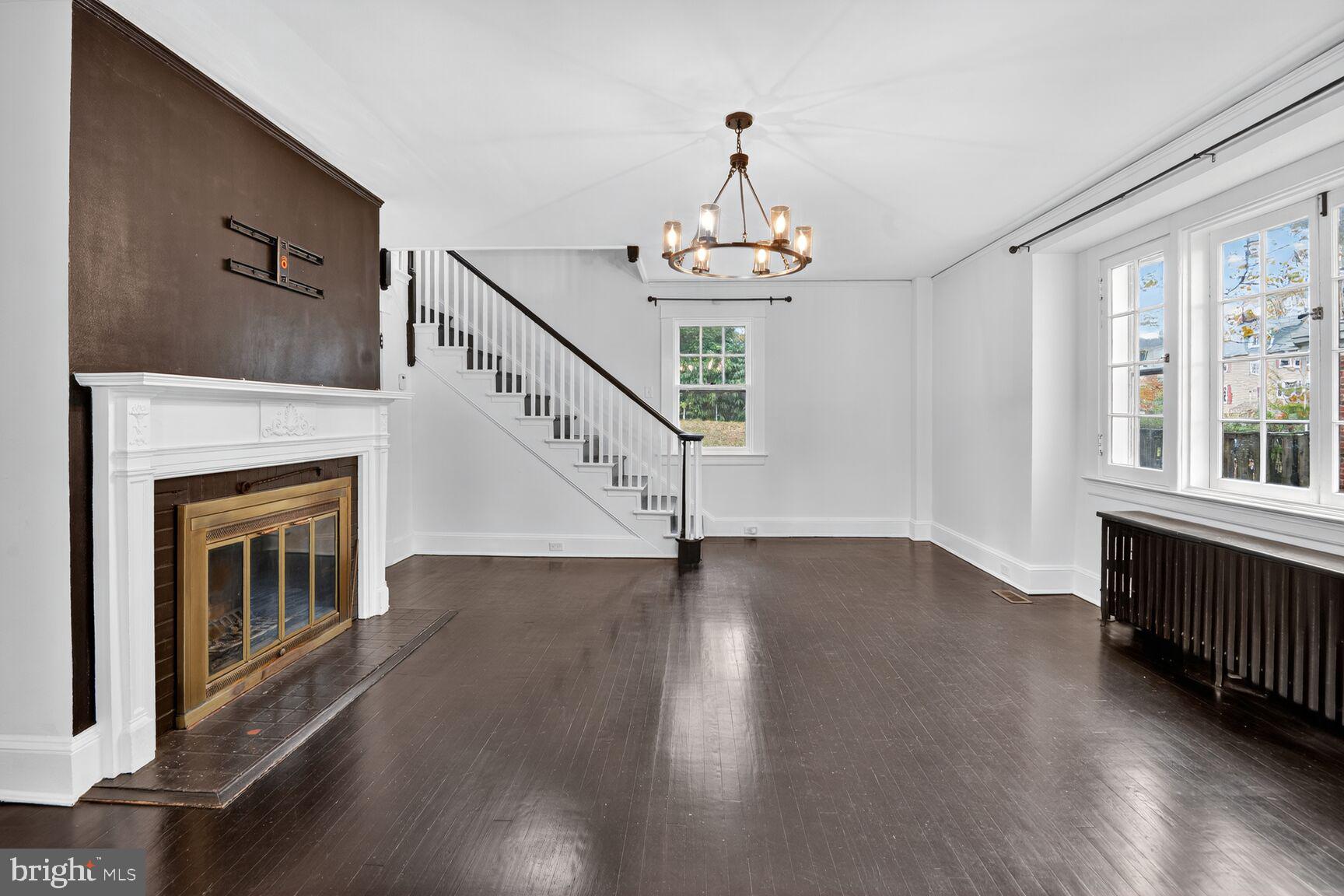 719 Brinkwood Road Baltimore, MD 21229 - Photo 4 of 31 a view of an empty room with wooden floor fireplace and a window