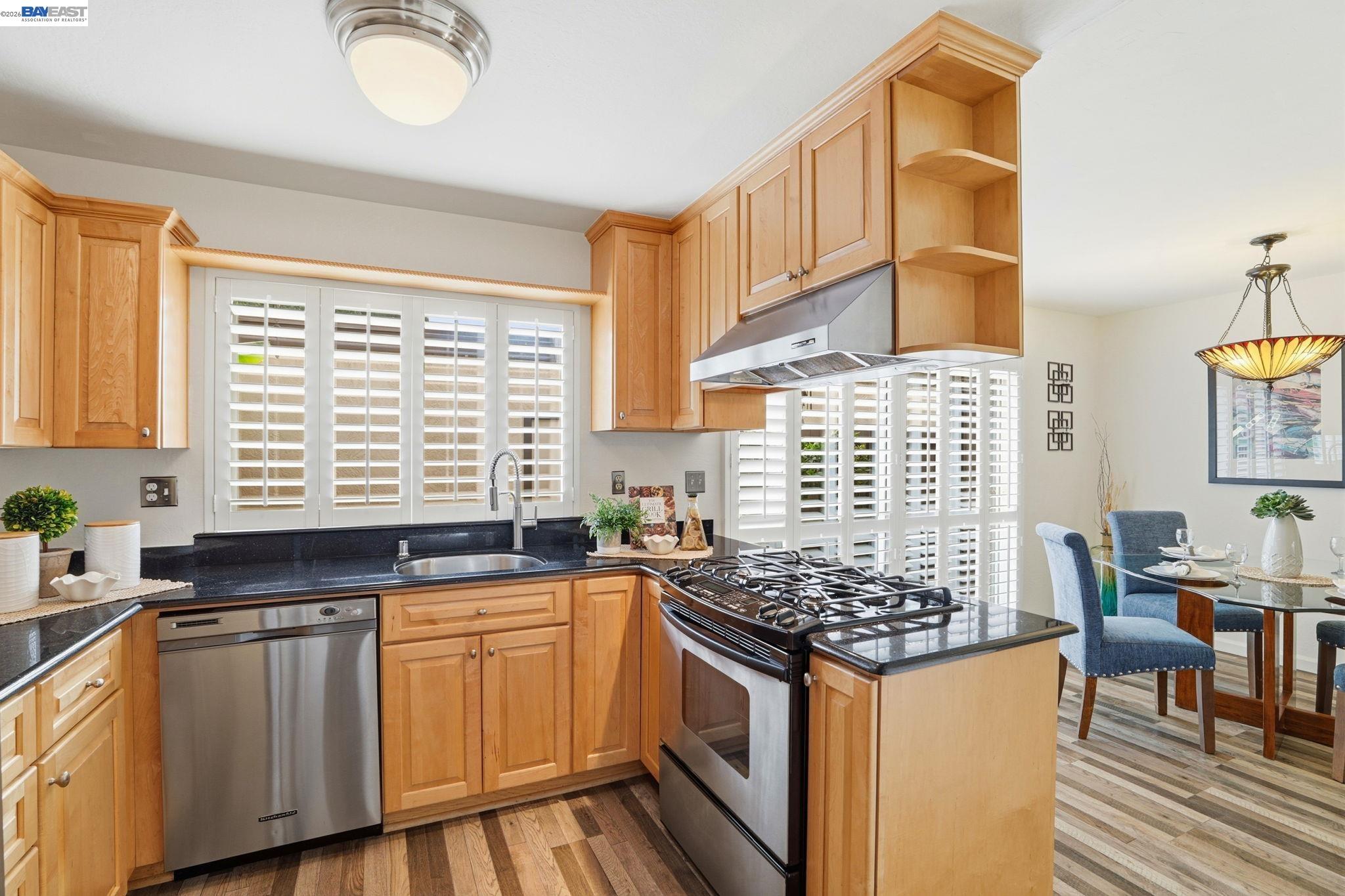 38524 Burdette Common Fremont, CA 94536 - Photo 17 of 35 a kitchen with stainless steel appliances granite countertop a stove a sink and a white wooden cabinets