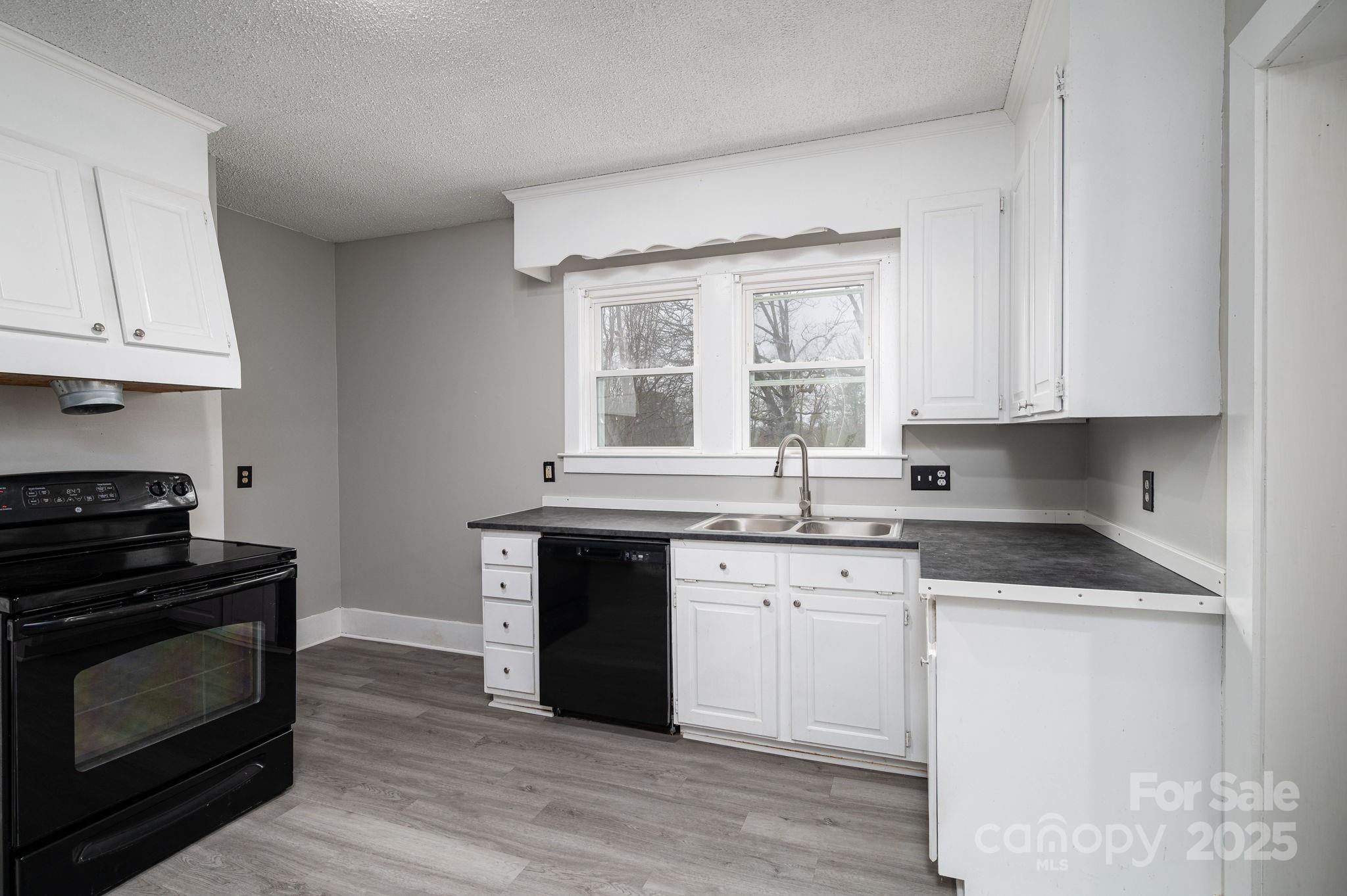 2645 Kool Park Road Northeast Hickory, NC 28601 - Photo 13 of 46 a kitchen with granite countertop a stove a sink and wooden floors