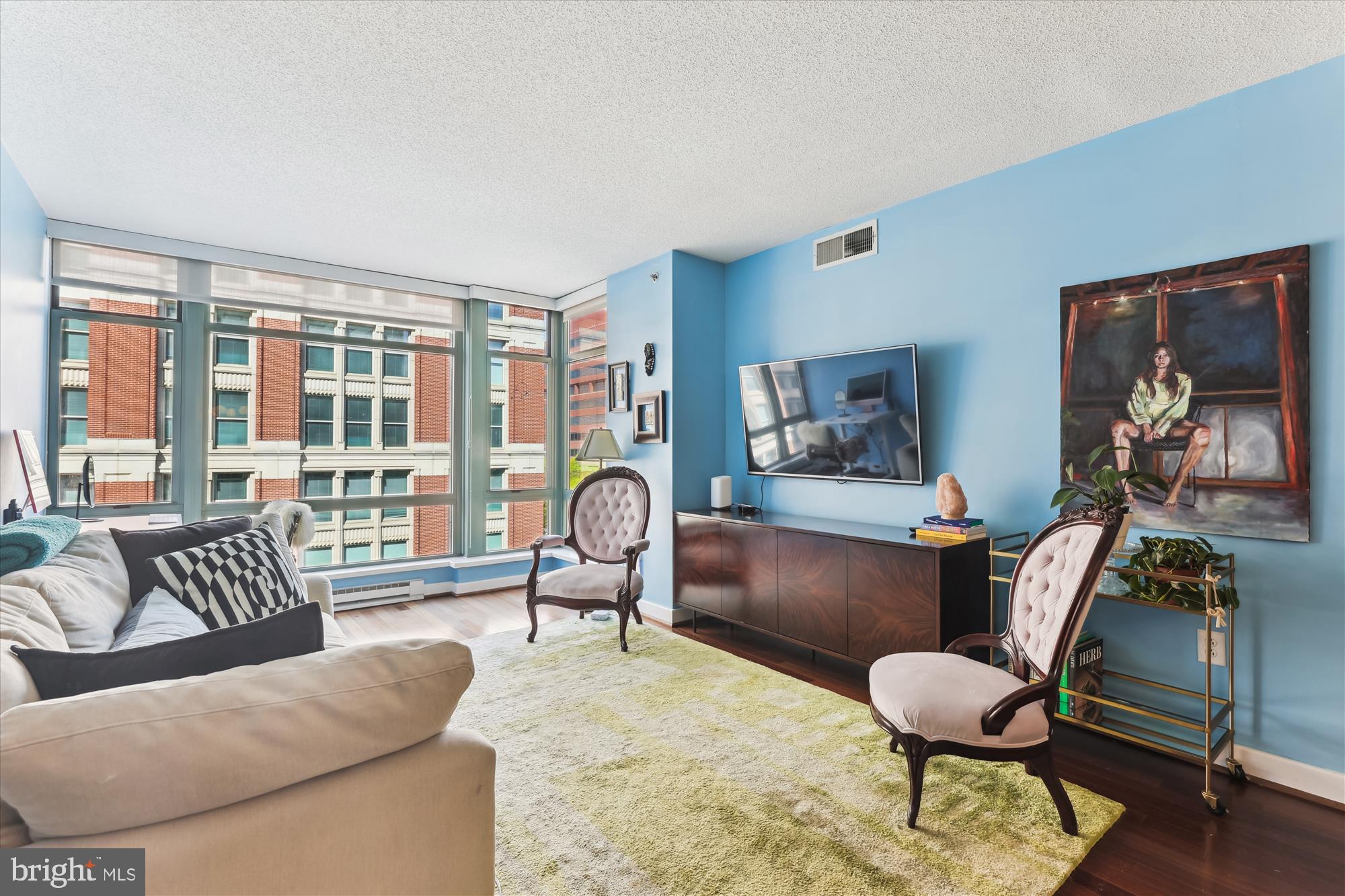 a living room with furniture and a floor to ceiling window
