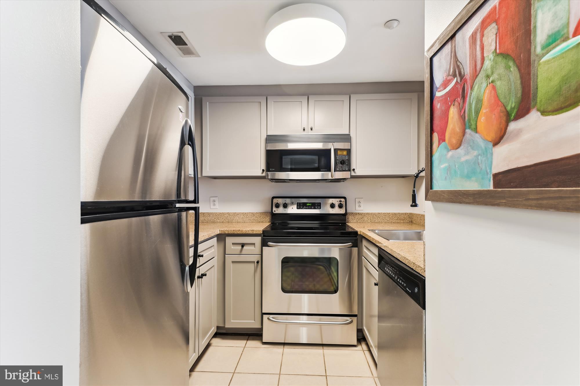 1150 K Street Northwest, Unit 706 Washington, DC 20005 - Photo 11 of 34 a kitchen with stainless steel appliances granite countertop a refrigerator sink and stove