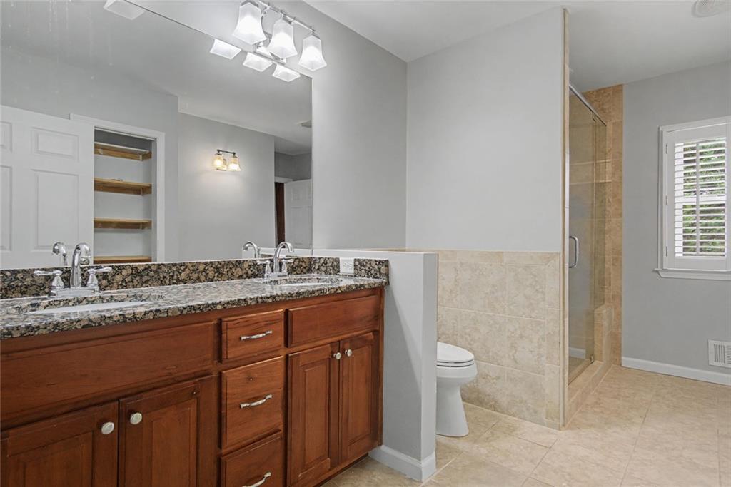 1001 Wiley Bridge Road Woodstock, GA 30188 - Photo 22 of 40 a bathroom with a granite countertop sink a toilet and a mirror