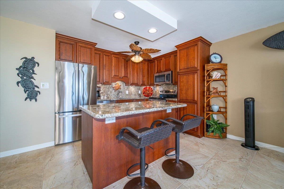 2387 South Kihei Road, Unit B303 Kihei, HI 96753 - Photo 21 of 48 a kitchen with stainless steel appliances granite countertop a refrigerator and a sink