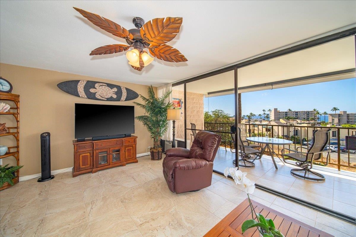 2387 South Kihei Road, Unit B303 Kihei, HI 96753 - Photo 25 of 48 a living room with furniture a flat screen tv and floor to ceiling window