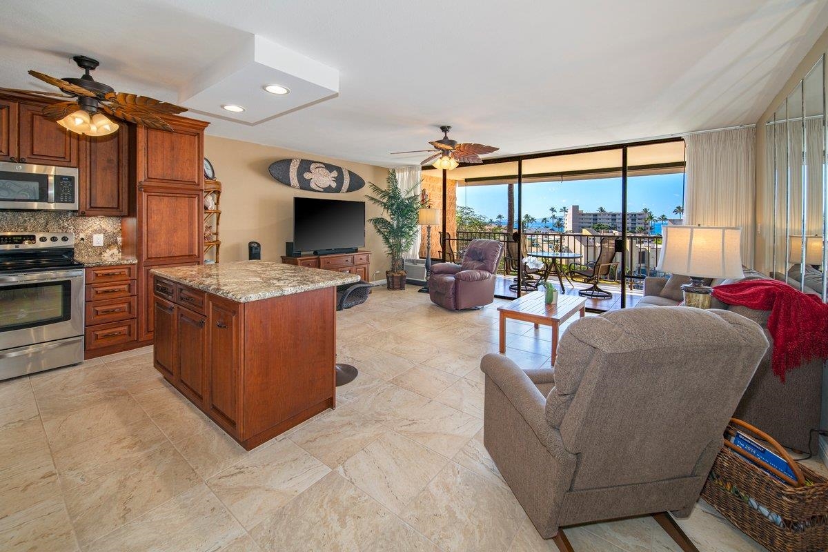 2387 South Kihei Road, Unit B303 Kihei, HI 96753 - Photo 3 of 48 a living room with furniture a flat screen tv and a large window